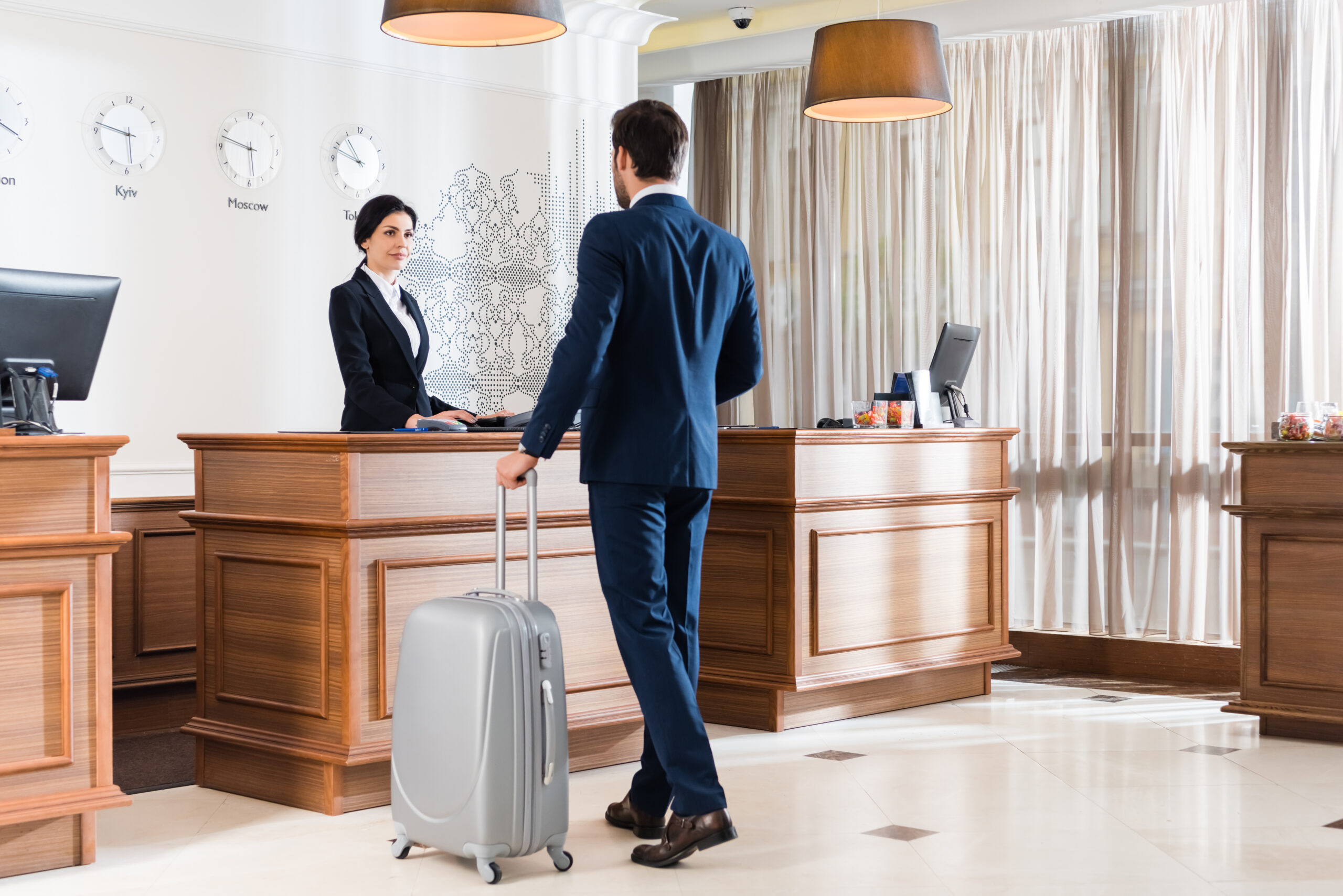 Traveler with luggage checking a flight departure board before traveling to Dubai and the UAE.